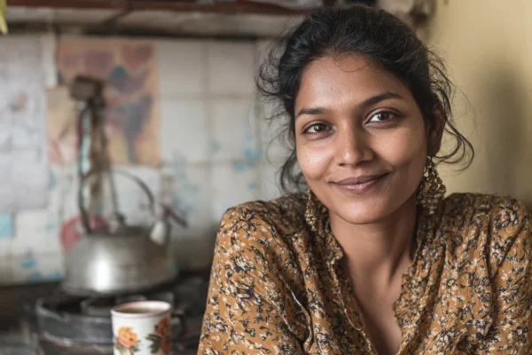 Indiase vrouw in haar keuken heeft net een kop smaakvolle thee ingeschonken.