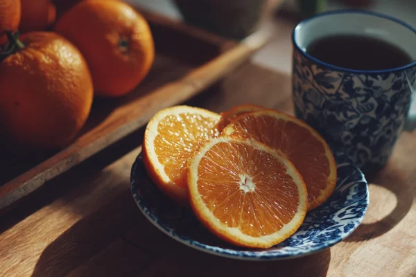 Een kopje fruitige sinaasappelthee met verse sinaasappelschijfjes.
